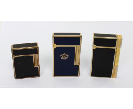 A vintage boxed Dupont black enamel and gilded cigarette lighter inscribed 'S. T. Dupont' and two other vintage lighters; a b