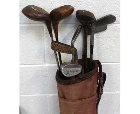A small collection of vintage golf clubs including two hickory-shafted examples, in bag.