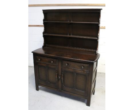 An Ercol 'Old Colonial' style dresser, two plate racks above two frieze drawers over two panelled cupboard doors to block sup