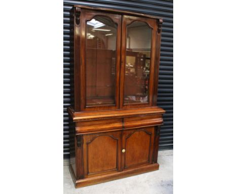 A Victorian mahogany bookcase, the upper section with twin glazed doors, the lower section with twin short drawers above cupb