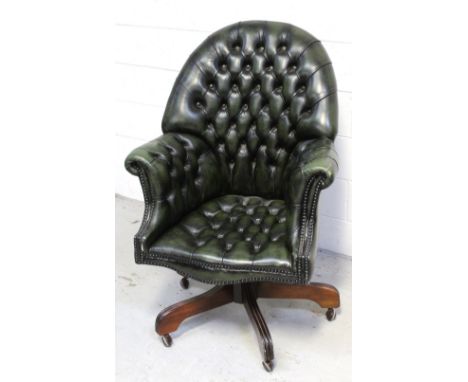 A vintage green leather Chesterfield swivel office chair on castors.