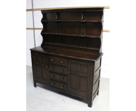 An Ercol 'Old Colonial' dresser, two plate racks over four drawers with panelled cupboard door to either side, 170 x 146cm.