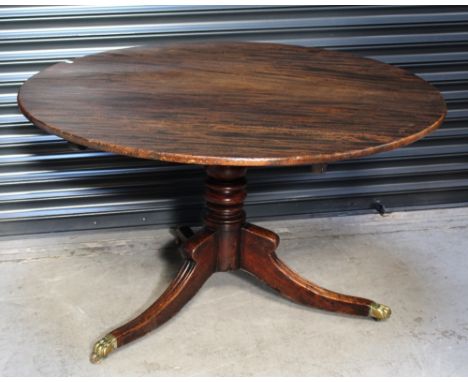 A 19th century walnut loo table raised on baluster and knopped column, to three outswept legs terminating in brass paw feet t