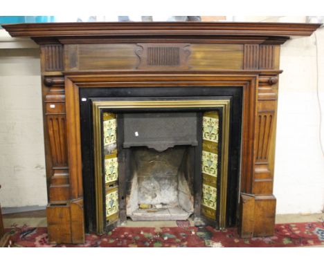 A Victorian fire plate, with tile surround and a mahogany mantelpiece and fender 135cm high, 180cm wide