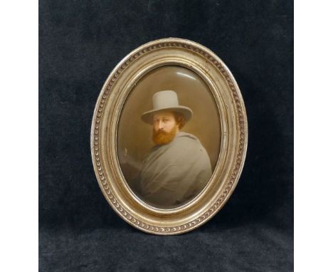 A late 19th century Continental oval porcelain plaque painted with a man wearing a grey cloak and hat, with ginger beard and 