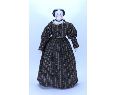 A glazed china shoulder head doll, German 1860s, with painted features, red lid lines and moulded black hair-style, on a clot