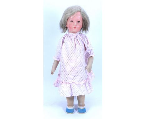 A Kathe Kruse cloth Doll, German circa 1930, the moulded synthetic head with painted features, shoulder length blonde hair an