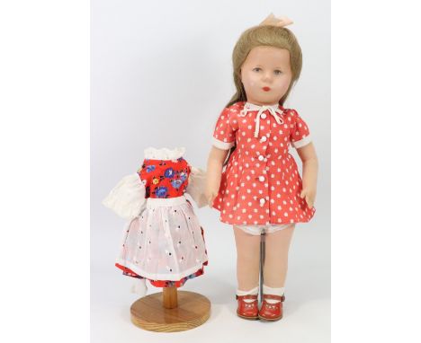 A Kathe Kruse doll in original clothes, German 1950s, the moulded synthetic head with painted features, long brown hair swept
