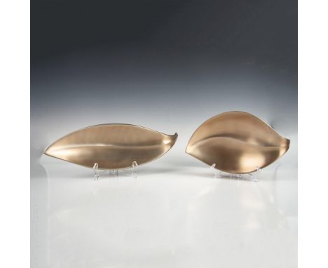 Brushed metal leaf shaped bowls/trays in a muted bronze color. Two smaller are 13"L x 7.75"W x 2"H. The longer is 19"L x 6"W 