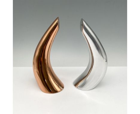 Curved aluminum horn with flat base. Nambe' backstamp. This item has its original box: 9"L x 7.5"W x 4"H. Artist: Karim Rashi
