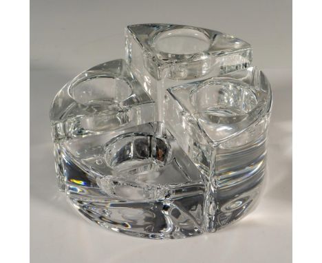 A set of 4 clear votive candle holders in various sized wedge pieces. Together the pieces form a circle. Orrefors marked. Tal
