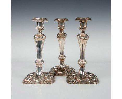 Rococo-style candlesticks adorned with hand-chased floral motifs, featuring sterling bodies filled with cement for stability.