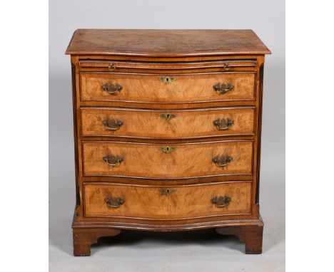 A mid Georgian style figured walnut veneered serpentine chest of four long drawers with a slide supported on bracket feet, 28