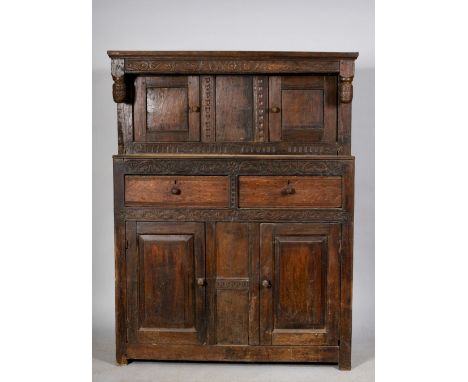 A late 17c oak court cupboard, the upper section with carved frieze bearing the date 1674 and having drop finials over cupboa