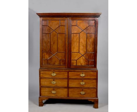 A late Georgian figure mahogany linen press, the upper section under a dentile moulded cornice, the geometric panelled doors 
