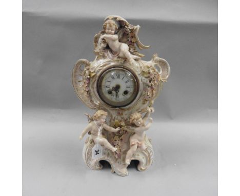 A late 19c German mantel clock in a porcelain case by Sitzendorf. It is of a cream colour and rococo in form and bearing thre