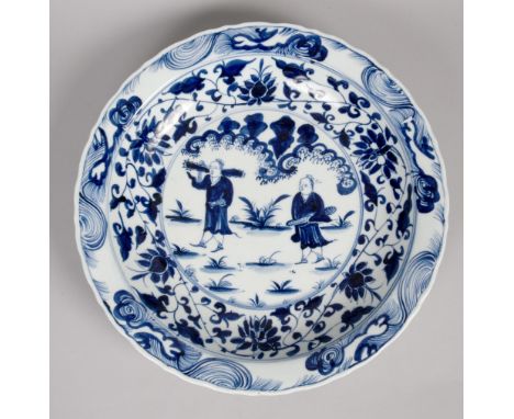 A Chinese bowl of large proportion decorated in blue and white, the central panel of two harvesters with outer band of leaf a