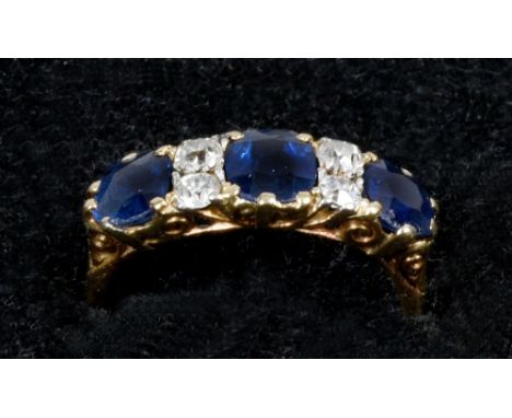 An 18ct gold ring set with three cut sapphires, each approx. .75ct and spaced by four cut diamonds.