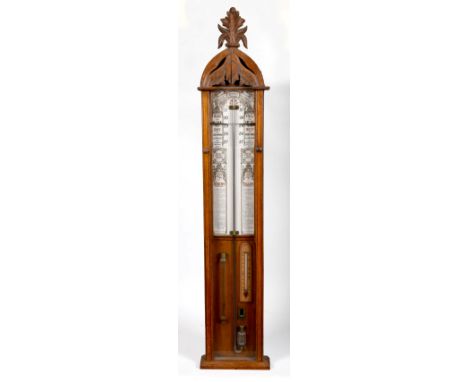 A late 19c Admiral Fitzroy's barometer in glazed oak case with round top carved with foliage and surmounted by a spray of lea