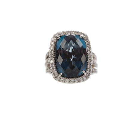 LONDON BLUE TOPAZ AND DIAMOND RING, the faceted topaz of approximately 16.00 carats bordered by round brilliant cut diamonds,