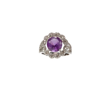 PURPLE GEM AND DIAMOND SET RING, set with a round purple gem, surrounded by round brilliant cut diamonds, on trifurcated diam
