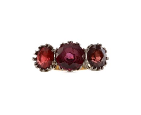 RED GEM SET THREE STONE RING, set with a central round red gem flanked by two smaller oval gems, size G, unmarked, 5.2g