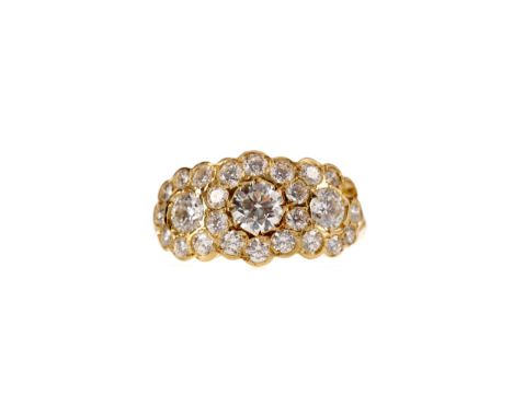 DIAMOND DRESS RING, set with three central round brilliant cut diamonds surrounded by smaller diamonds, the diamonds totallin