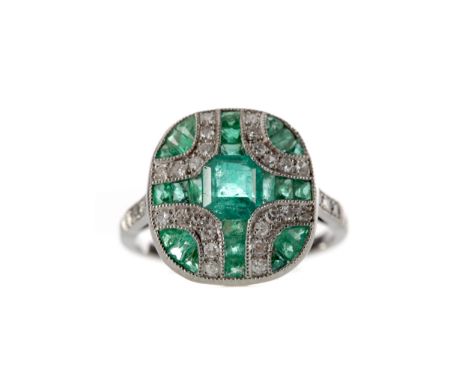 EMERALD AND DIAMOND RING, set with an emerald cut emerald flanked by calibre cut emeralds and round brilliant cut diamonds to