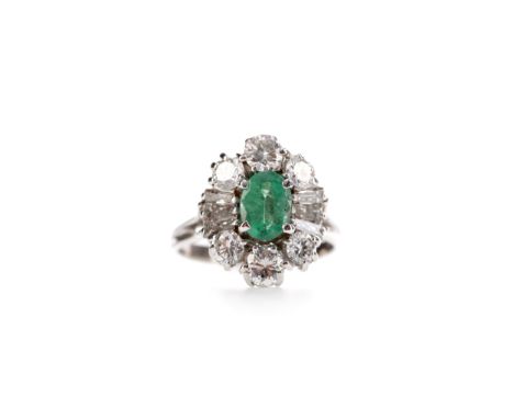 EMERALD AND DIAMOND RING, set with an oval emerald of approximately 0.80 carats flanked by tapered baguette and round brillia