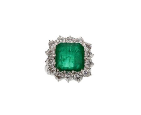 EMERALD AND DIAMOND RING, set with a central emerald cut emerald of approximately 3.85 carats with evidence of oil treatment,