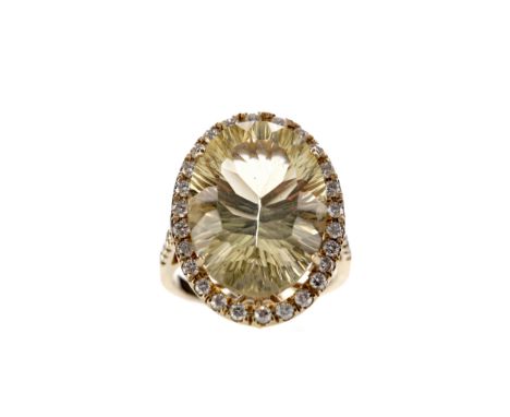LEMON QUARTZ AND DIAMOND RING, set with an oval lemon quartz 20mm long within a halo of round brilliant cut diamonds, on diam