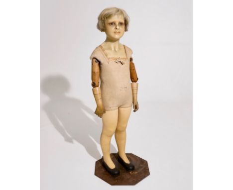 A French wax head mannequin doll of a girl, Pierre Imans, Paris, ca. 1920 H.: 102 cm  The body stamped P. IMANS - PARIS, the 
