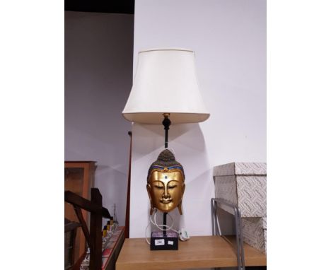 A DECORATIVE TABLE LAMP WITH A GILT BUDDHA HEAD