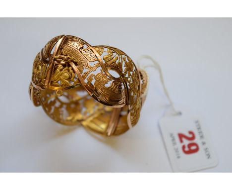 A South American yellow metal hinged bangle, decorated figures with Llamas and Inca style motifs.