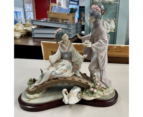 A large Lladro figure group of two women on a bench.