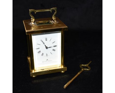 A BRASS CASED CARRIAGE CLOCK  the enamel dial with Roman numerals, signed Matthew Norman, 8-day movement striking on a coiled