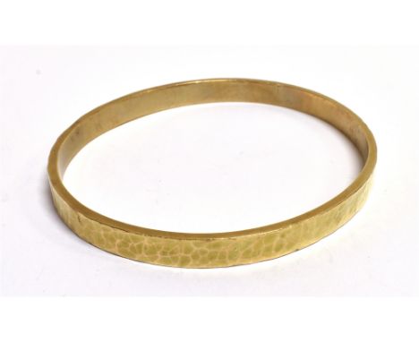 AN UNMARKED HAMMERED YELLOW METAL BANGLE  width 0.6cm, measurement 7 x 6.5cm, weight 32g Condition: Bangle is slipover (no cl