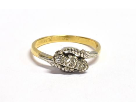 AN 18CT GOLD PLATINUM AND DIAMOND CROSSOVER RING The three single cut diamonds set in patterned platinum in an open work moun