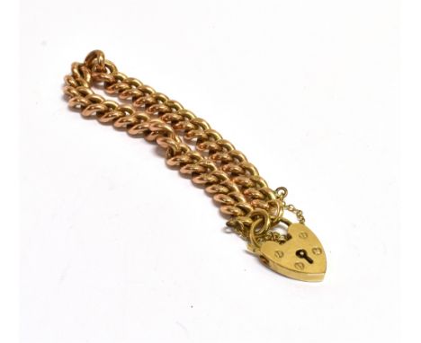 A 9CT ROSE GOLD CURB LINK BRACELET The bracelet fitted with a 9ct yellow gold heart padlock and safety chain, the bracelet wi