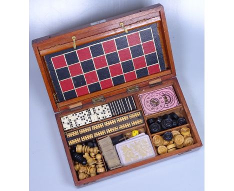 A Victorian mahogany games compendium, the interior fitted with cribbage board, chess men, dominoes, draughtsmen etc, box len