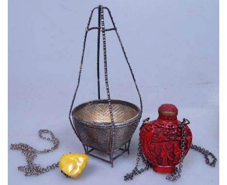 A Chinese lacquer perfume bottle on chain, 5.5cm, a natural amber pendant, and a Chinese white metal basket