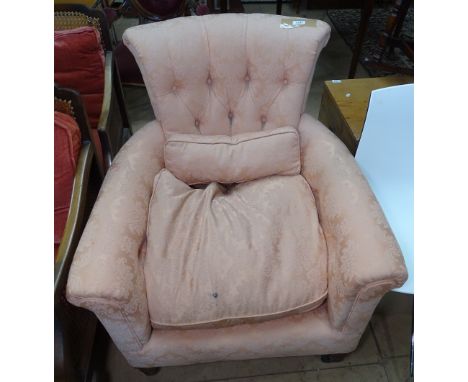 A Victorian button-back upholstered armchair on turned legs