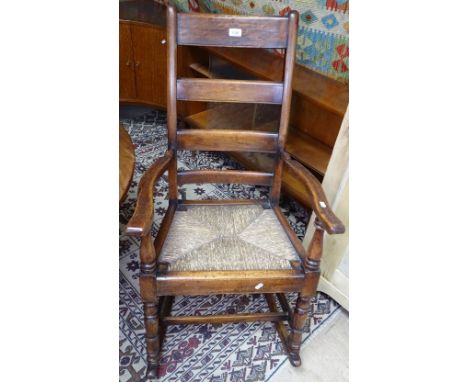 An Antique mahogany ladder-back rocking chair, with rush seat