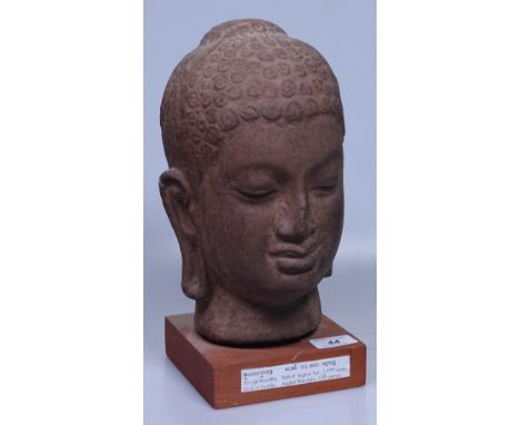 An Angkor Wat style ceramic Buddha head on wood plinth, height 12"