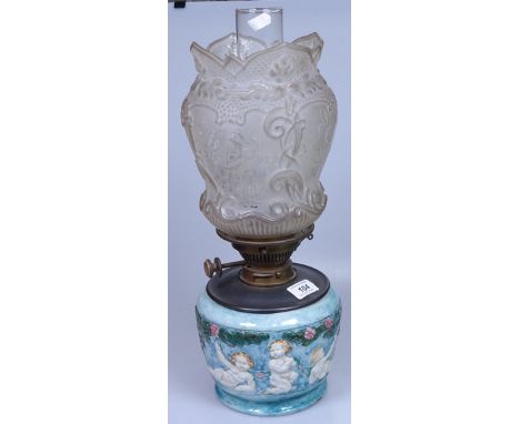An embossed and painted pottery oil lamp, with shade and chimney, 18" overall 