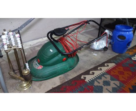 A Qualcast lawnmower, brass fire irons, a glazed strawberry pot, and a mesh fireguard