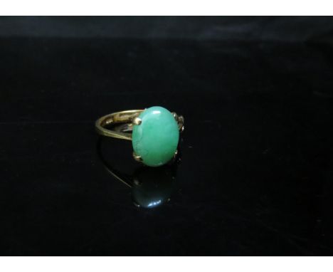 A gold ring set with an oval cabochon jade, stamped 18k. Size O, 3.3g 