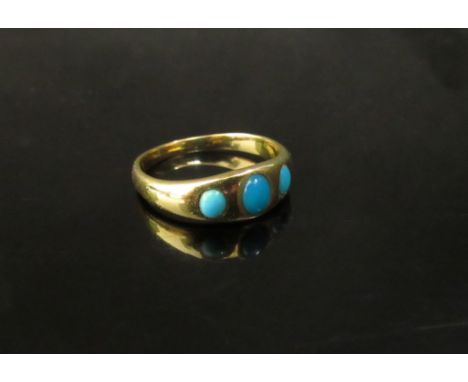 A gold ring with three cabochon turquoise in rubover setting, unmarked. Size O, 3.5g 