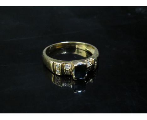 A gold ring set with a central oval sapphire flanked by four diamonds on stepped shoulders, stamped 18k. Size N, 3.5g 