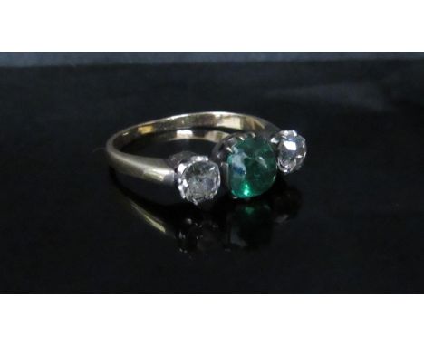 A yellow gold emerald and diamond ring the central cabochon cut emerald 6mm diameter, 5mm deep flanked by 0.25ct approx brill